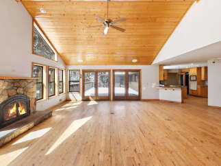 This stunning property boasts a spacious open-plan living area with soaring ceilings and large windows that bathe the room in natural light.