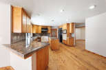 This stunning kitchen boasts beautiful wood flooring and granite countertops, creating a warm and inviting atmosphere.