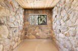 This rustic shower boasts a unique stone wall design, creating a natural and charming atmosphere.