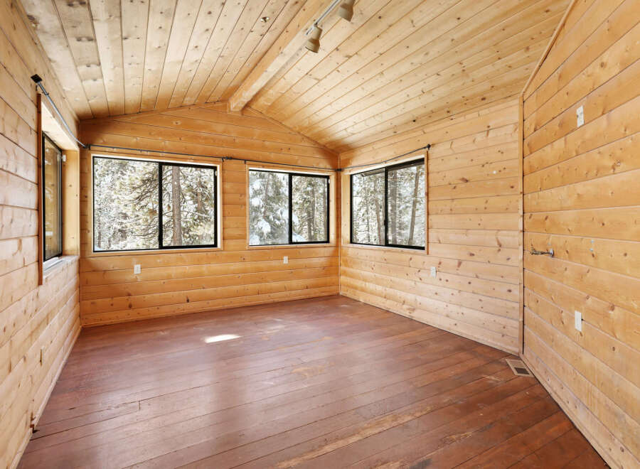 This charming cabin boasts a spacious interior with knotty pine walls and ceilings, creating a warm and inviting atmosphere.