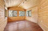 This charming cabin boasts a spacious interior with knotty pine walls and ceilings, creating a warm and inviting atmosphere.