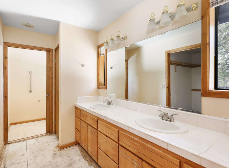 This bathroom boasts dual sinks with ample counter space, perfect for a busy morning routine.