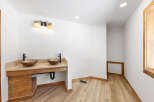 This stunning bathroom boasts dual sinks with modern bronze faucets, nestled into a custom wooden vanity.