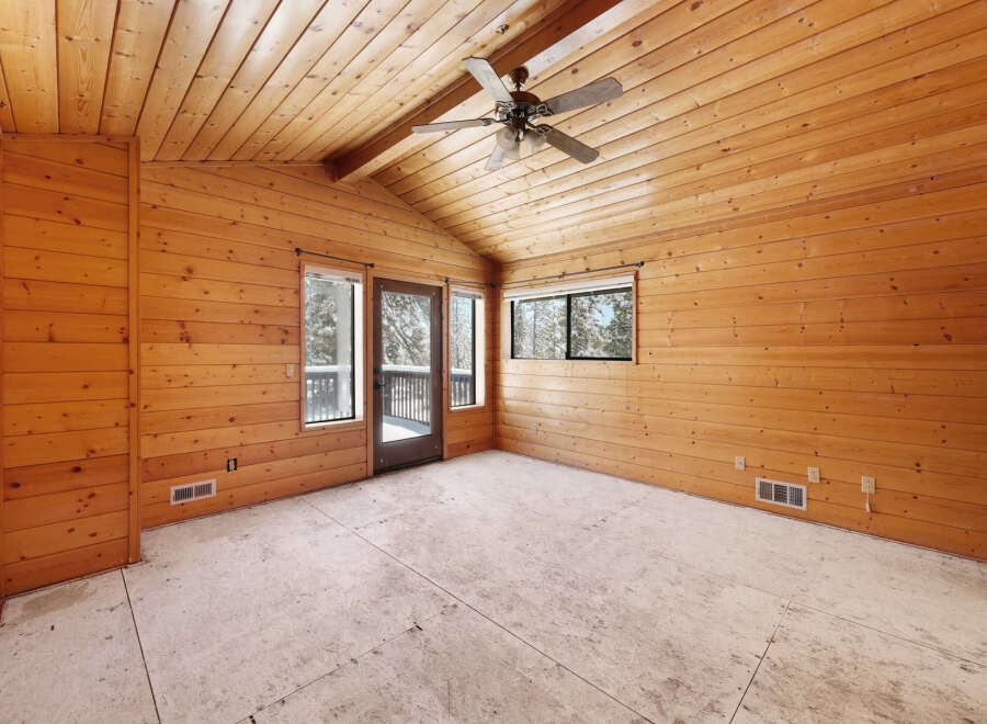 This spacious room boasts a stunning wood-paneled ceiling and walls, creating a warm and inviting atmosphere.