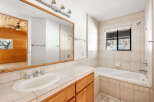 This charming bathroom boasts a wood vanity, complementing the wood-paneled adjacent room visible through the mirror.