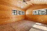 This stunning log cabin boasts a spacious interior with vaulted ceilings and large windows offering breathtaking views of the snowy landscape.