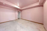 This spacious room features light pink walls and a concrete floor, offering a blank canvas for customization.
