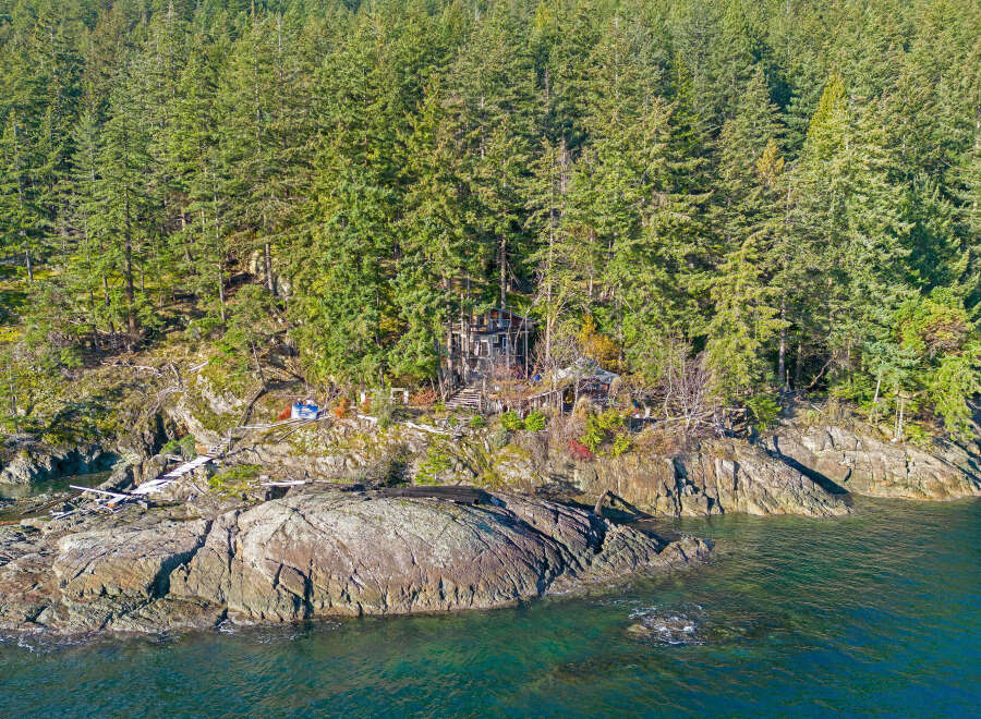 Secluded waterfront property nestled in a lush forest setting.