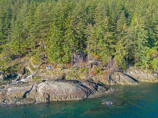 Secluded waterfront property nestled in a lush forest setting.
