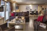 This stunning apartment boasts a spacious living area with comfortable seating, perfect for relaxing after a day on the slopes.