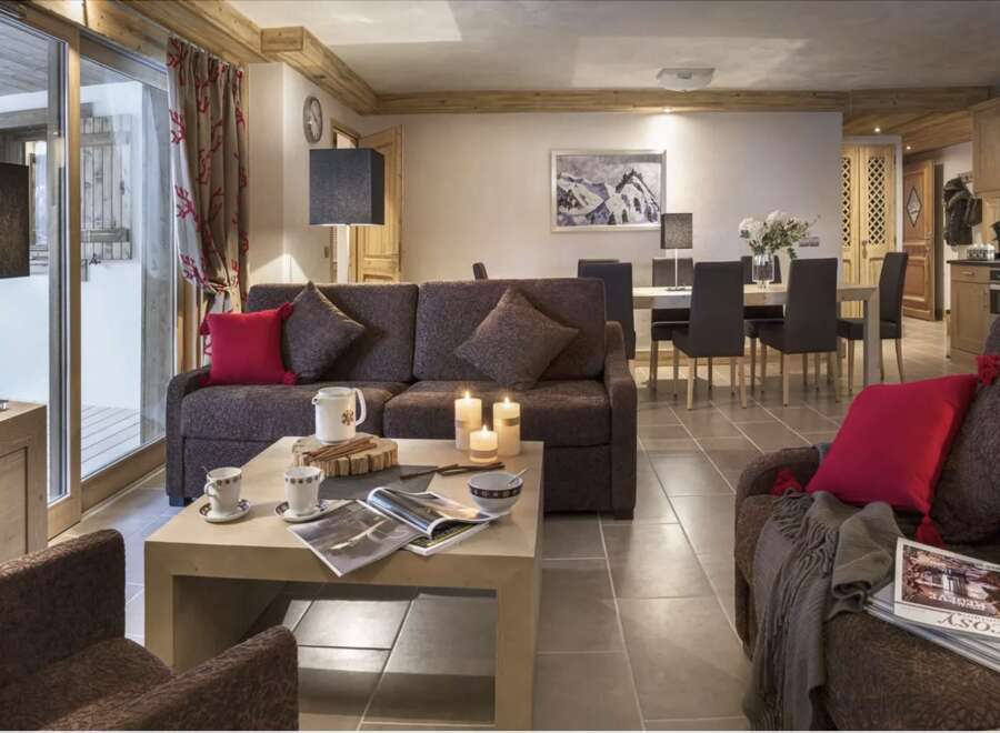 This stunning apartment boasts a spacious living area with comfortable seating, perfect for relaxing after a day on the slopes.