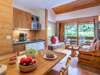 Cozy chalet apartment with fully equipped kitchen and dining area.