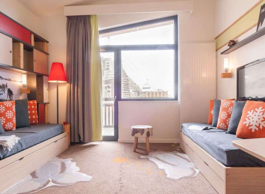 Cozy apartment featuring built-in storage, comfortable sofa beds, and a large window offering stunning mountain views.