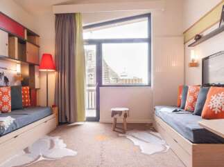 Cozy apartment featuring built-in storage, comfortable sofa beds, and a large window offering stunning mountain views.