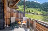 Enjoy breathtaking mountain views from your private balcony, complete with comfortable seating and a small table.