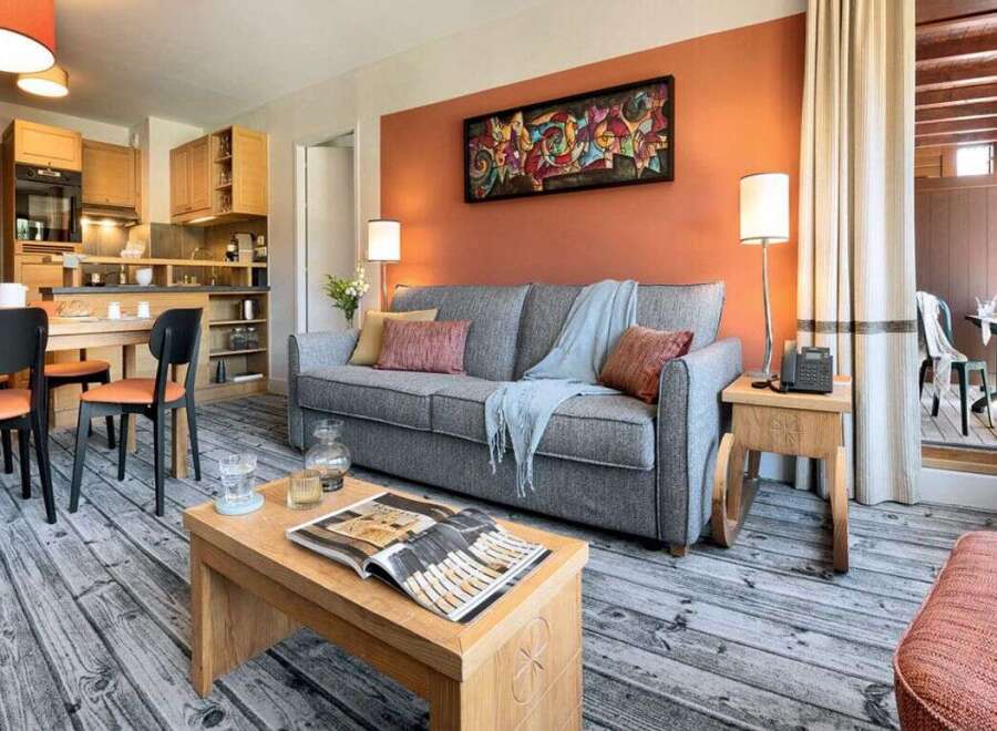 Cozy apartment featuring a well-equipped kitchen, comfortable living area with sofa and dining space.
