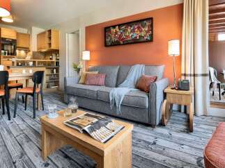 Cozy apartment featuring a well-equipped kitchen, comfortable living area with sofa and dining space.