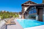 Luxury resort nestled in the French Alps, boasting stunning mountain views and a heated outdoor pool.