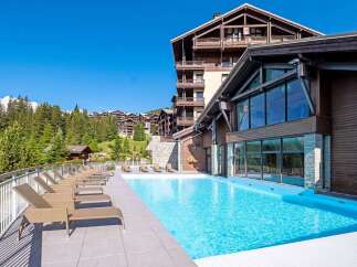 Luxury resort nestled in the French Alps, boasting stunning mountain views and a heated outdoor pool.