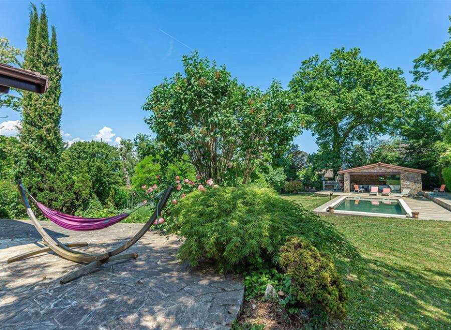 This stunning property boasts a luxurious outdoor space, complete with a hammock for relaxation and a refreshing swimming pool.