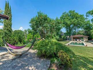 This stunning property boasts a luxurious outdoor space, complete with a hammock for relaxation and a refreshing swimming pool.