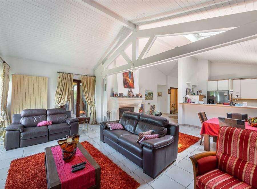 Stunning open-plan living area with high ceilings and exposed beams, creating a spacious and airy atmosphere.