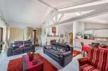 Stunning open-plan living area with high ceilings and exposed beams, creating a spacious and airy atmosphere.