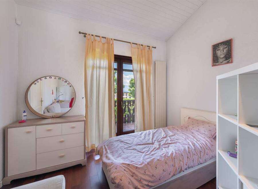 Charming bedroom with a view: This cozy space features a comfortable bed, ample storage, and a lovely view from the window.