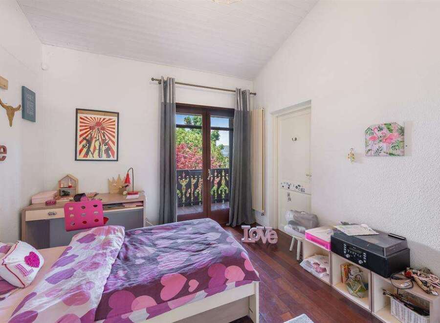 Charming bedroom with balcony access, showcasing a lovely view.