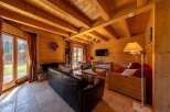 Cozy wooden chalet with large windows offering stunning mountain views.