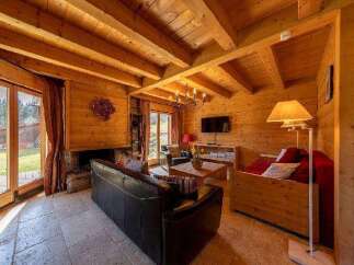 Cozy wooden chalet with large windows offering stunning mountain views.