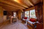 This stunning chalet boasts a spacious open-plan living area with large windows offering breathtaking mountain views.
