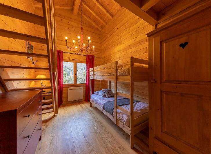 Cozy chalet bedroom with wooden bunk beds, perfect for families or groups.