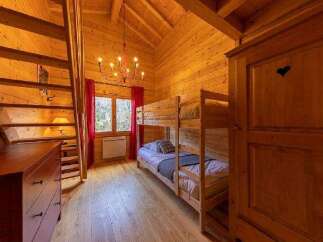 Cozy chalet bedroom with wooden bunk beds, perfect for families or groups.