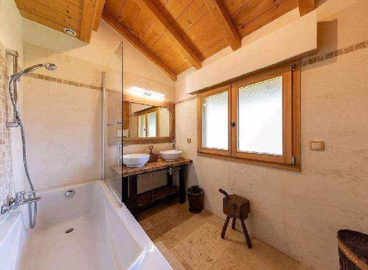 This luxurious bathroom boasts a spacious bathtub, double sinks, and a walk-in shower, perfect for relaxation.