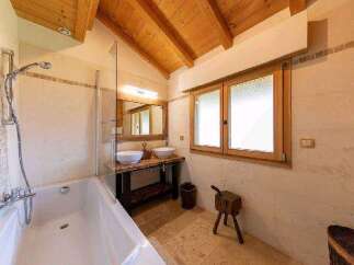 This luxurious bathroom boasts a spacious bathtub, double sinks, and a walk-in shower, perfect for relaxation.