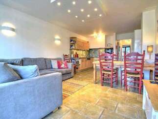 This stunning apartment boasts an open-plan living area with a comfortable sofa and a fully equipped kitchen.