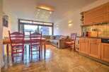 This charming apartment boasts a spacious living area with large windows offering stunning mountain views, a fully equipped kitchen, and a cozy dining area perfect for family meals.