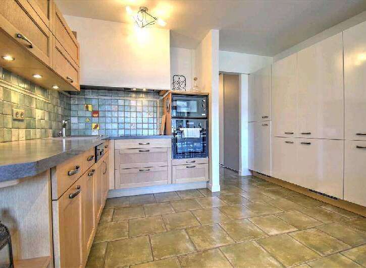This stunning kitchen boasts modern light wood cabinetry, complemented by sleek countertops and a stylish backsplash.