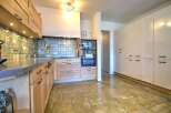 This stunning kitchen boasts modern light wood cabinetry, complemented by sleek countertops and a stylish backsplash.