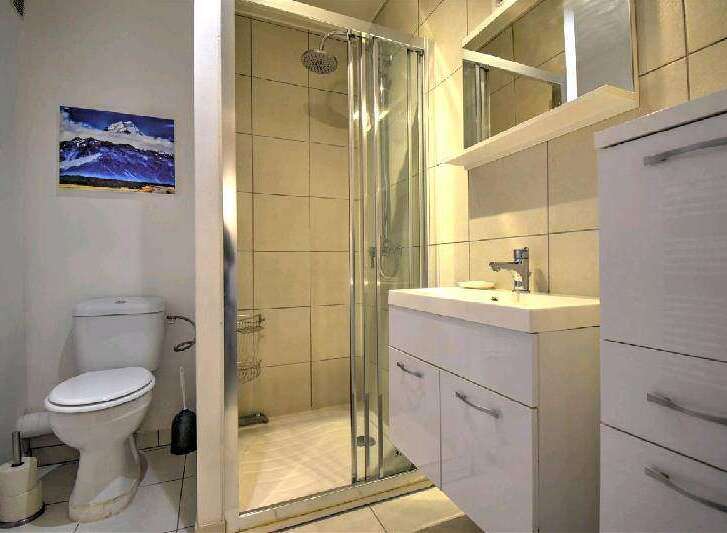 This stunning bathroom boasts a modern design with a spacious shower and sleek white vanity.