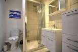 This stunning bathroom boasts a modern design with a spacious shower and sleek white vanity.