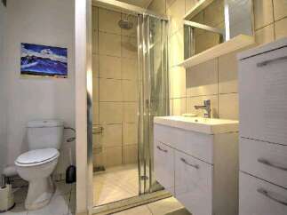 This stunning bathroom boasts a modern design with a spacious shower and sleek white vanity.