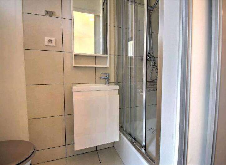 Modern bathroom with a walk-in shower, stylish vanity, and contemporary tile.