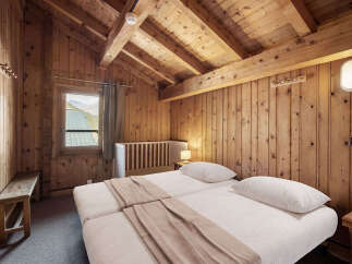 Cozy chalet bedroom with twin beds, wooden walls, and mountain views.