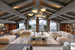Experience luxury mountain living in this stunning chalet, featuring a spacious living area with plush, modular sofas and a striking stone coffee table.