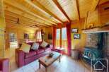 This stunning chalet boasts a spacious open-plan living area with exposed wooden beams, a cozy fireplace, and large windows offering breathtaking views.