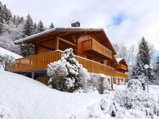 This stunning chalet boasts a beautiful wooden exterior, spacious balconies perfect for enjoying mountain views, and a cozy interior ideal for a winter getaway.