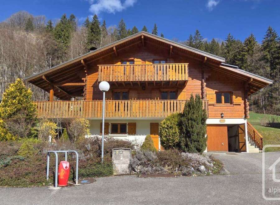 This stunning chalet boasts a spacious wooden exterior, two balconies offering breathtaking views, and a convenient attached garage.