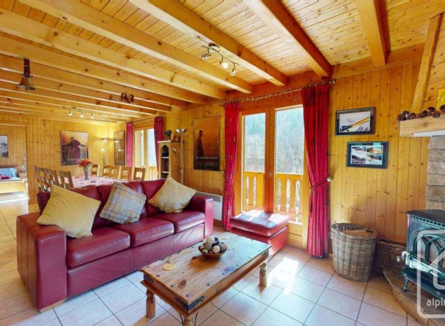 This charming chalet boasts a spacious open-plan living area with a wood-burning stove, creating a cozy atmosphere.